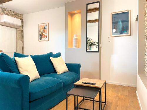 Sofá azul en la sala de estar con mesa en L'intemporel - Grand T2 climatisé & terrasse, en Castres