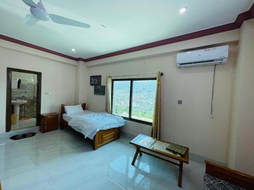 sypialnia z łóżkiem, oknem i stołem w obiekcie Kashmir Heaven Guest House w mieście Muzaffarabad