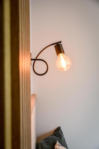a lamp hanging on a wall next to a wall at Podtatrzańskie Apartamenty in Nowy Targ