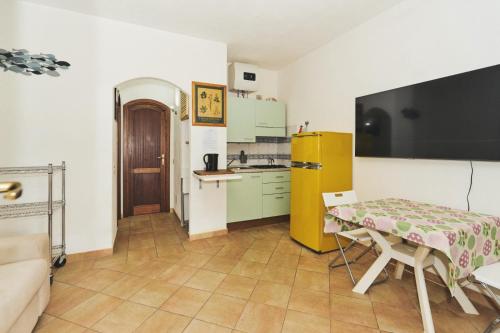 a small kitchen with a table and a yellow refrigerator at LA CASA DI LINDA in Porto Ottiolu