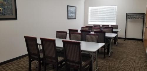 a dining room with tables and chairs and a window at Baymont by Wyndham Harlan in Harlan