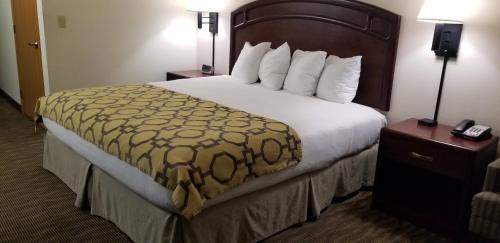 a hotel room with a large bed with a yellow blanket at Baymont by Wyndham Harlan in Harlan