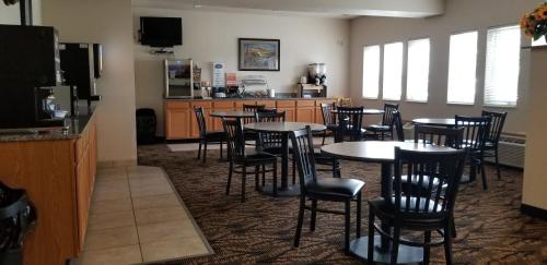 a dining room with tables and chairs and a kitchen at Baymont by Wyndham Harlan in Harlan