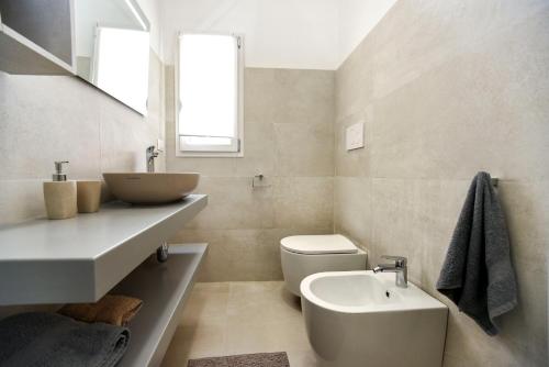 a white bathroom with a sink and a toilet at Zeituna Lodge a Porto Cesareo in Torre Lapillo