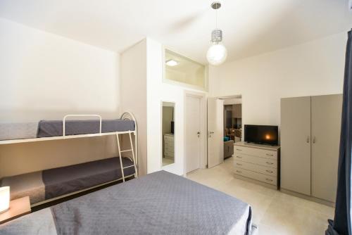 1 dormitorio con litera y TV en Zeituna Lodge a Porto Cesareo, en Torre Lapillo