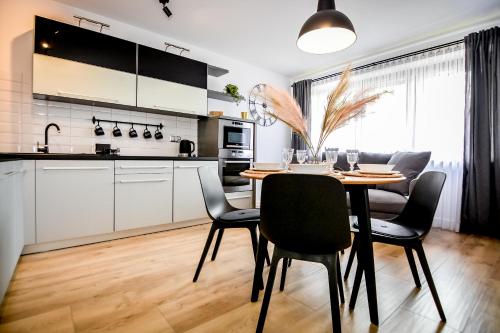 a kitchen and dining room with a table and chairs at Podtatrzańskie Apartamenty in Nowy Targ