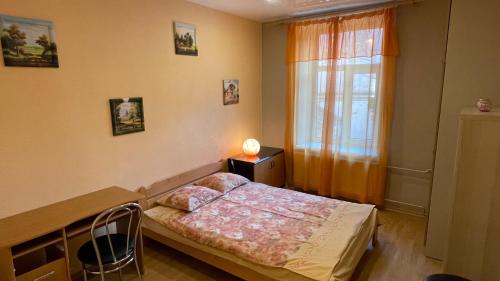 um quarto com uma cama, uma mesa e uma janela em Quiet and cozy rooms in the center near the Old Town em Riga