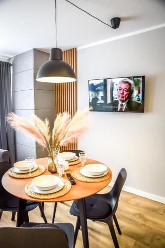 a dining room with a wooden table and chairs at Podtatrzańskie Apartamenty in Nowy Targ