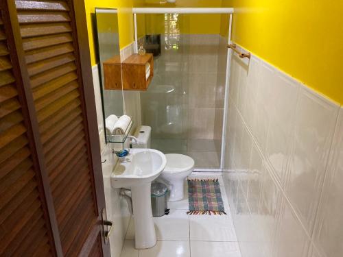 a small bathroom with a toilet and a sink at Casa Araribá - Ilha Grande in Abraão