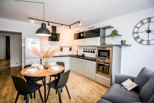 a kitchen and dining room with a table and chairs at Podtatrzańskie Apartamenty in Nowy Targ