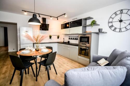 a kitchen and living room with a table and chairs at Podtatrzańskie Apartamenty in Nowy Targ