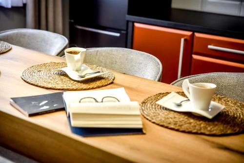 a wooden table with chairs and two cups of coffee at Podtatrzańskie Apartamenty in Nowy Targ