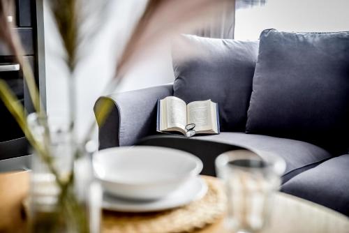 a book sitting on a couch with a table at Podtatrzańskie Apartamenty in Nowy Targ