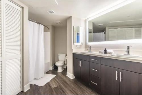 uma casa de banho com um lavatório, um WC e um espelho. em 3BDR and 2 BTH apt in SM, 5 min to beach with Pool, Gym and Free parking em Los Angeles