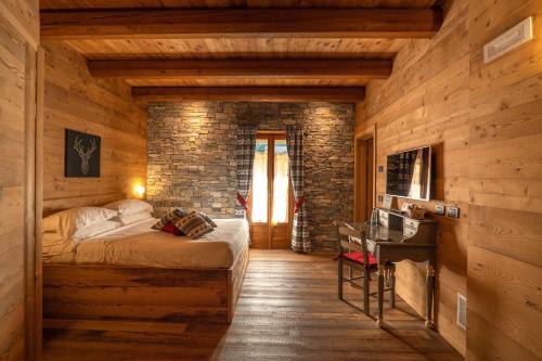 een slaapkamer met een bed en een bakstenen muur bij B&B San Sebastiano in Vernante