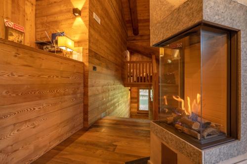 a living room with a fireplace in a log cabin at B&B San Sebastiano in Vernante