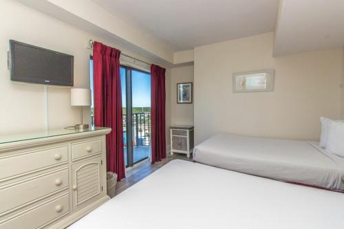 a bedroom with two beds and a flat screen tv at The Palace 1513 in Myrtle Beach