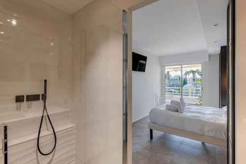 Cette chambre comprend un lit et une salle de bains pourvue d'une douche. dans l'établissement Superbe Appartement avec Piscine et Toit Terrasse, à Cannes