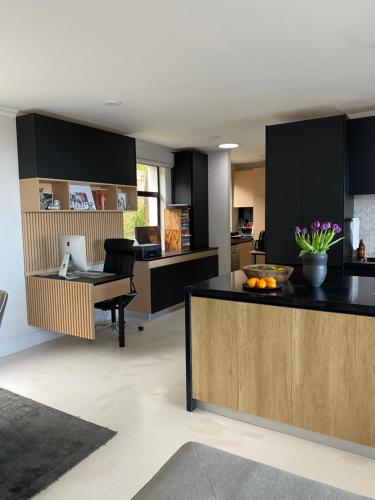a kitchen with black cabinets and a desk with a laptop at Constantia View Apartments- Luxury Self Catering in Cape Town