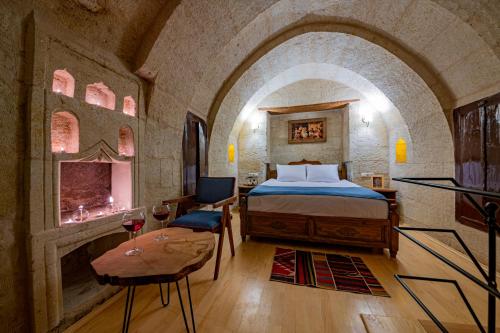 a bedroom with a bed and a table in a room at Janus Cappadocia Hotel in Nevsehir