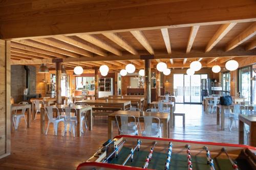 restauracja ze stołami i krzesłami oraz stołem bilardowym w obiekcie Village Huttopia Sud Ardèche w mieście Vagnas