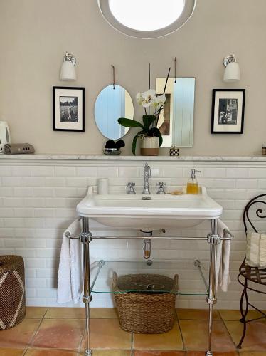 une salle de bain avec un lavabo et un miroir dans l'établissement Le Mas de la Rose, à Taradeau