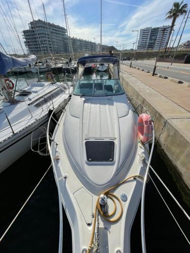 a white boat is docked in a harbor at Yate Eos in Badalona