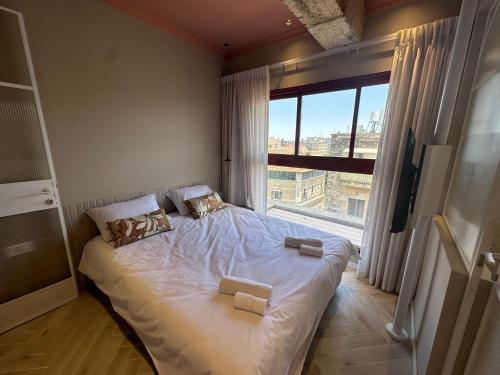 Bett in einem Zimmer mit einem großen Fenster in der Unterkunft GoodHouse 402 - 4 Bdr beautiful apartment in Jerusalem in Jerusalem