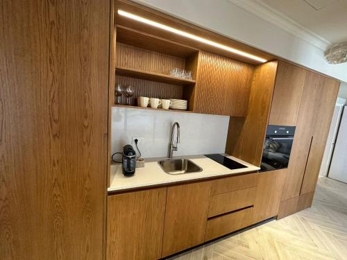 eine Küche mit einer Spüle und Holzschränken in der Unterkunft GoodHouse 402 - 4 Bdr beautiful apartment in Jerusalem in Jerusalem