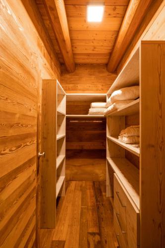 a room with wooden walls and shelves in a log cabin at B&B San Sebastiano in Vernante