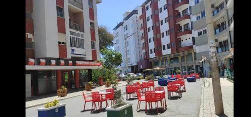 a row of red chairs and tables on a city street at Lovely Apartment In Mindelo City Center in Mindelo