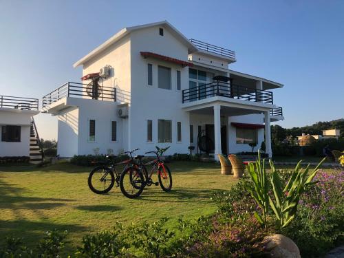 two bikes parked in front of a house at Hriday Bhoomi - Luxury Cottages & Villa in Jim Corbett in Jhirna
