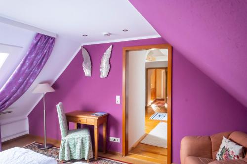 a purple attic room with a table and a chair at NATURION Hotel Hinterzarten in Hinterzarten