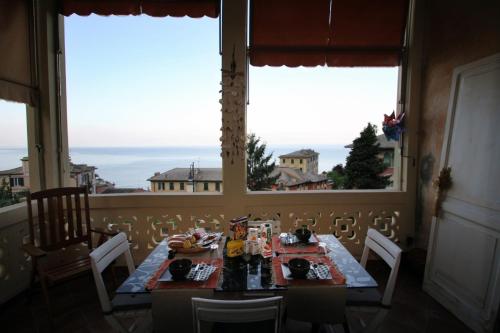 a dining room with a table and two windows at L'Andirivieni in Camogli