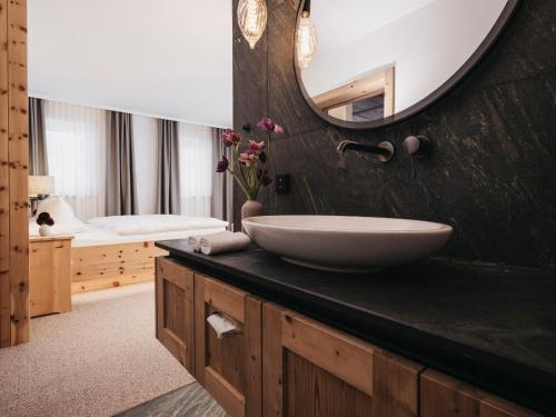 een badkamer met een wastafel en een spiegel bij Almwellness-Resort Tuffbad in Sankt Lorenzen im Lesachtal