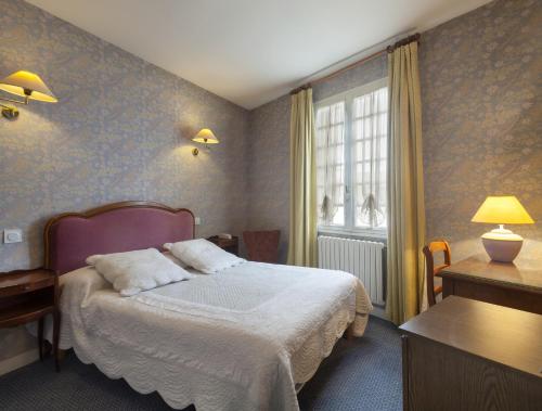 Habitación de hotel con cama y ventana en Au Relais du Porhoet, en Guilliers