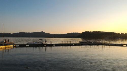 a dock on a lake with a boat in the water at Appartamento Biò in Borgofranco dʼIvrea
