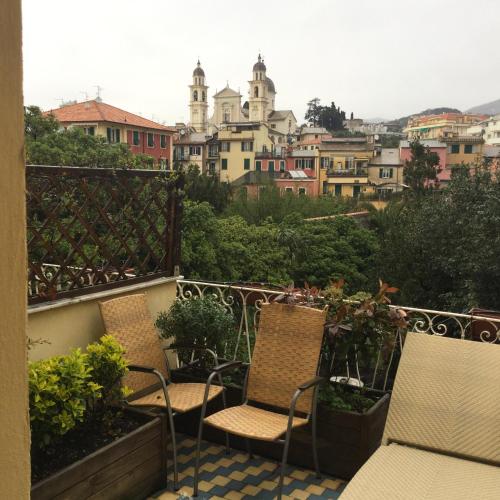 a balcony with two chairs and a view of a city at Hotel Miramare in Lavagna