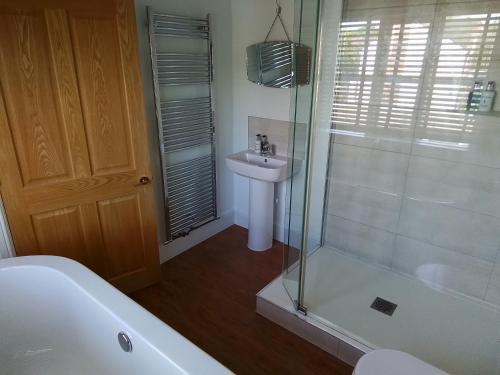 a bathroom with a shower and a sink and a tub at The Horse and Cart in Peasmarsh