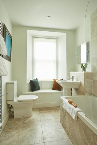 a bathroom with a tub and a toilet and a sink at Victorian House in Grasmere