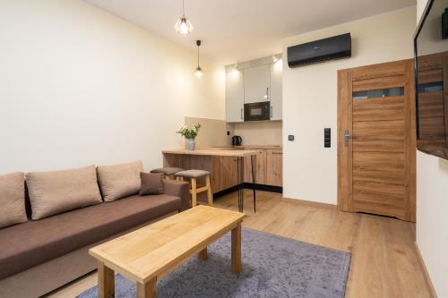 a living room with a couch and a table at Apartamenty Olimpijska by RENT4YOU in Olsztyn