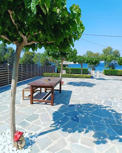 a wooden bench next to a tree with a stuffed animal at Enigma Boutique Houses Koxyli in Marmarion