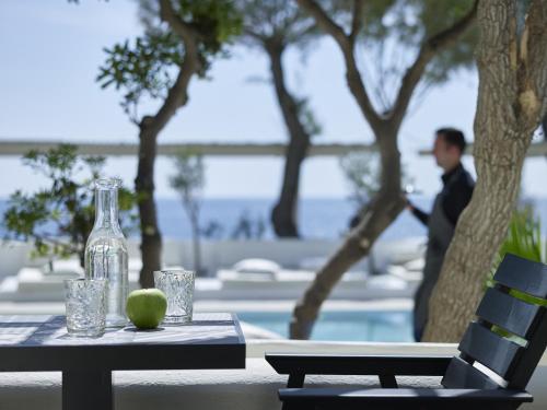 a table with a glass bottle and an apple on it at Bellonias Villas in Kamari