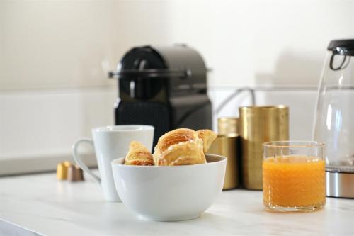 a bowl of bread and a glass of orange juice at La Villa Ponsin in Cognac