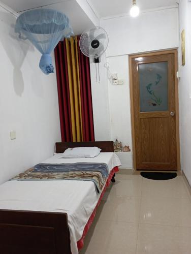 a room with two beds and a fan and a door at 152-Abhaya Place Homestay in Talalla