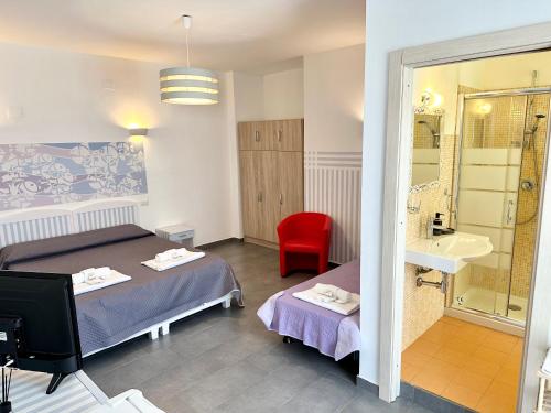 a room with two beds and a bathroom with a sink at Vintage in Alghero