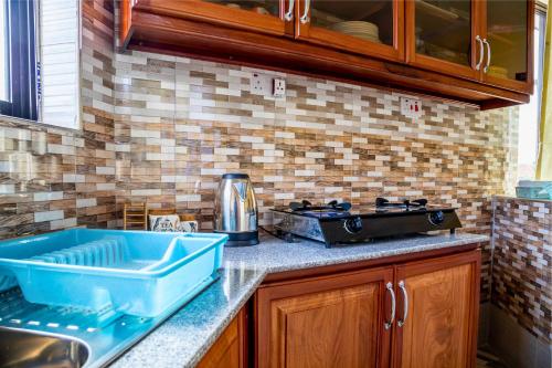 a kitchen with a blue sink and a stove at City Gem by Havana Properties near the French Embassy, Tanzanite Bridge & Coco Beach in Dar es Salaam