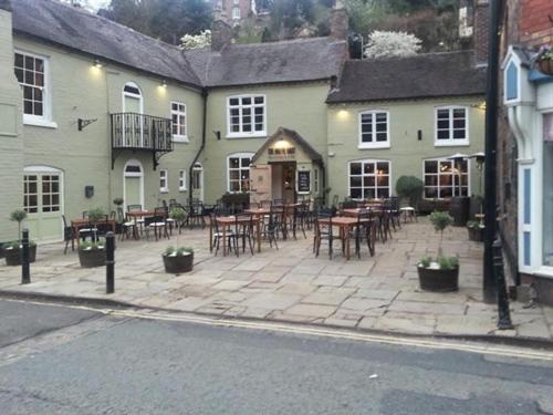 a patio with tables and chairs in front of a building at White Hart Inn in Ironbridge