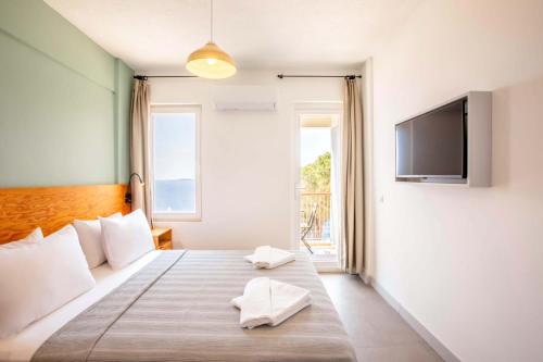 a bedroom with a bed with white pillows and a television at Mavilim Hotel in Kas