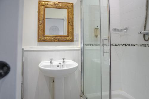 a bathroom with a sink and a shower with a mirror at White Hart Inn in Ironbridge